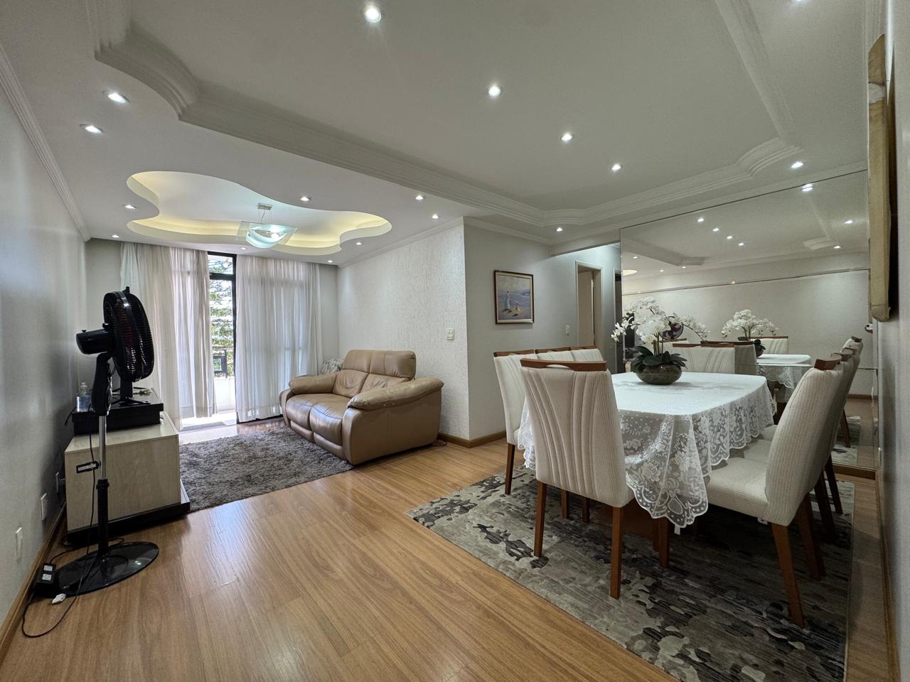Sala de estar e jantar integradas, com piso em madeira e acesso à varanda
